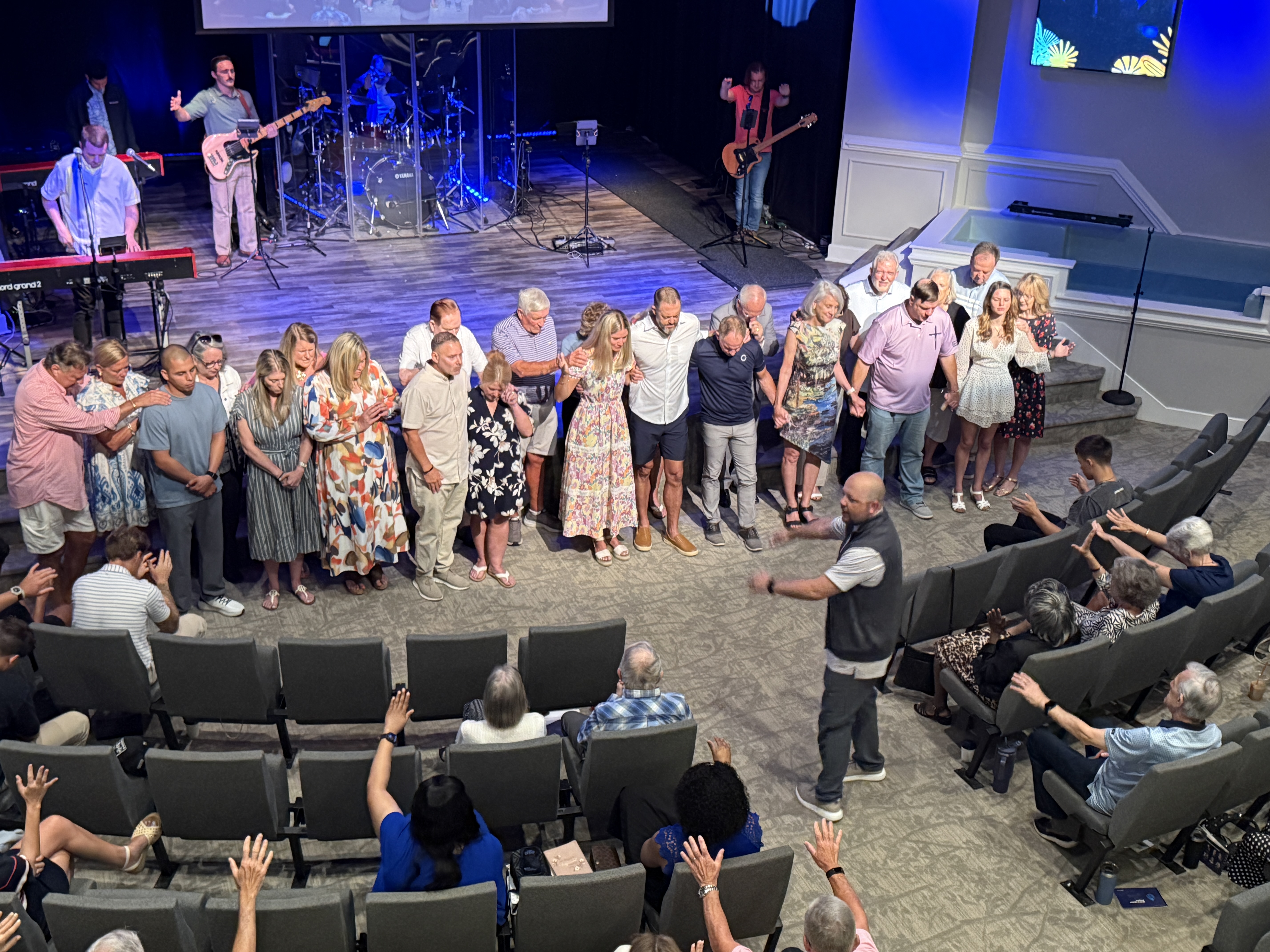 The church laying hands on the team in prayer
