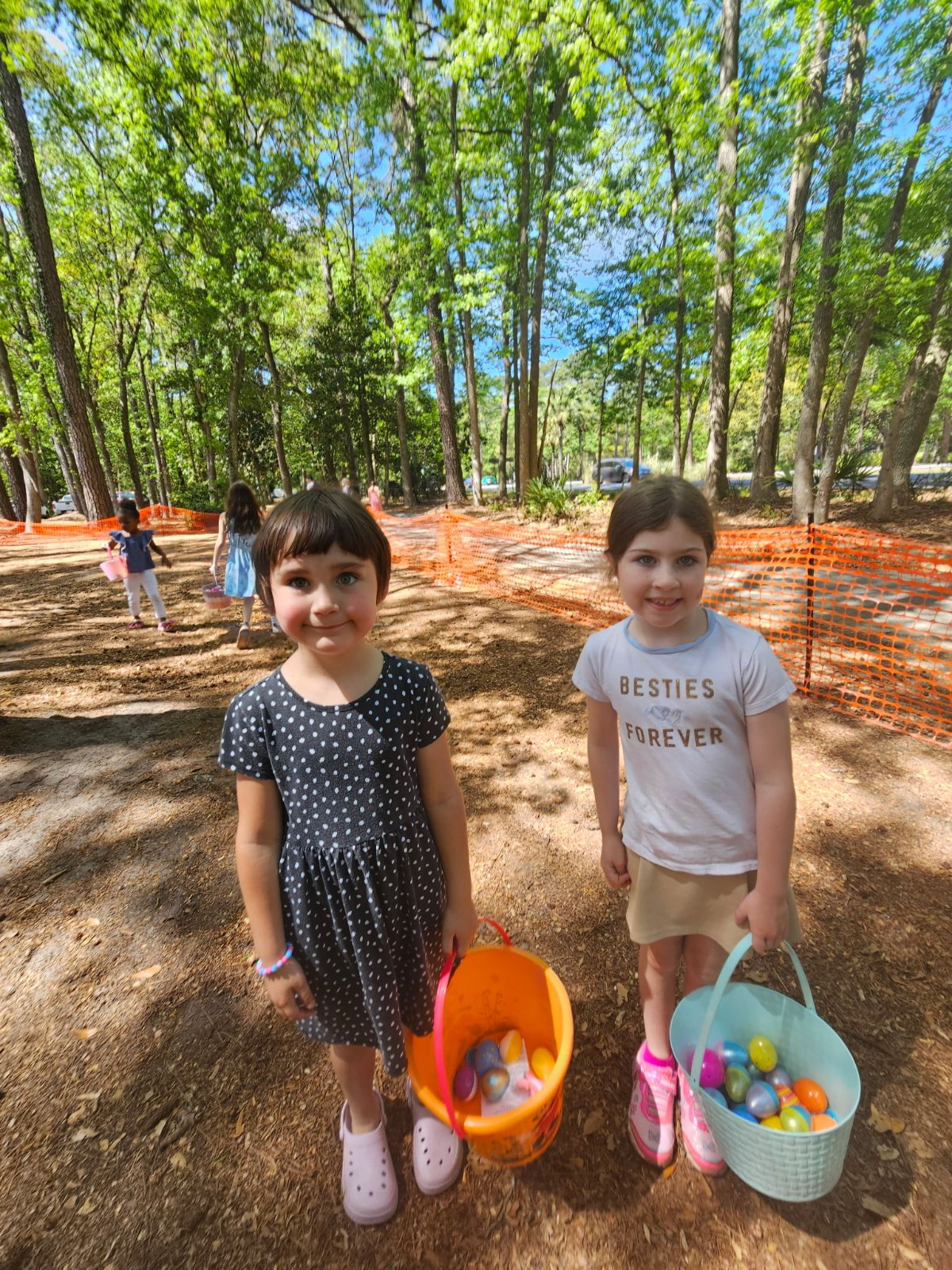 Two kids showing off their Easter egg hunt baskets